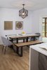The dining room features an industrial white oak table and benches with matte black steel frame, a geometric chandelier by Bobo Intriguing objects, and shaved wood art pieces by West Elm. Photo 4 of St. Johns Mid-Century Remodel modern home