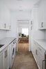 The new modern laundry layout features built in compact washer/dryer and painted shaker cabinetry. Photo 8 of St. Johns Mid-Century Remodel modern home
