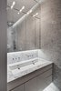 Modern home with Refrigerator, Mirror Backsplashe, Cooktops, Wall Oven, Range Hood, Microwave, Dishwasher, Wine Cooler, Interior, Metal, Sliding Door Type, Wall Mount Sink, Stone Slab Wall, One Piece Toilet, Marble Floor, and Living Room. Upper Level: Master Bathroom. The lighting scheme was designed to enhance the spatial qualities. Photo 9 of Noho Duplex, New York