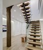 Modern home with Interior, Metal, Sliding Door Type, Metal Tread, Wood Tread, Metal Railing, Glass Railing, and Staircase. Staircase: View of Lower Level Family Room
The biggest single challenge was in the design and fabrication of the staircase. The stair was required to be both code and child safety compliant. The staircase’s unique features include the co-planar clear-tempered glass-rails and the child-proof open slots under the welded bent steel angles. Supported by a sizable post concealed in the wall behind the stair, stair attachments are made with moment connections. All metalwork on this job, including the stairs and door panels were site fabricated forging a unique hand-crafted industrial product, difficult to shop replicate. Photo 10 of Noho Duplex, New York