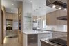 Modern home with Kitchen, Stone Counter, White Cabinet, Metal Cabinet, Laminate Cabinet, Wood Cabinet, Vinyl Floor, Stone Slab Backsplashe, Ceiling Lighting, Pendant Lighting, Refrigerator, Wall Oven, Cooktops, Range Hood, Ice Maker, Dishwasher, Microwave, Wine Cooler, and Undermount Sink. Kitchen Photo of State-of-the-Art Central Park Kitchen, NY