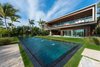 Modern home with House Building Type, Wood Siding Material, Outdoor, Large Pools, Tubs, Shower, Back Yard, and Grass. The home's modern exterior features glass, wood, and concrete. Photo of Pine Tree North