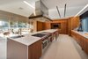 Modern home with Trees, Gardens, Concrete Patio, Porch, Deck, Shrubs, Chair, Sofa, Recessed Lighting, Limestone Floor, and Kitchen. Spacious and bright, the kitchen features a large island with seating and opens up to the living area. Photo 7 of Pine Tree North