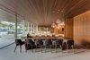 Modern home with Trees, Gardens, Shrubs, Concrete Patio, Porch, Deck, Chair, Sofa, Recessed Lighting, Limestone Floor, Stone Counter, Wood Cabinet, Range Hood, Range, Drop In Sink, and Dining Room. Teak wood and glass dominate the interior space of the home creating a mid-century modern feel. Photo 8 of Pine Tree North
