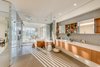 Modern home with Trees, Sofa, Gardens, Chair, Shrubs, Concrete Patio, Porch, Deck, Limestone Floor, Stone Counter, Wood Cabinet, Range Hood, Range, Drop In Sink, Table, Bed, Recessed Lighting, Bench, Night Stands, and Bath Room. An abundance of natural light peeks through the master bath. Photo 10 of Pine Tree North