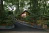 Modern home with Trees, Hardscapes, Storage Room Type, Picture Window Type, Rooftop, Casement Window Type, Outdoor, Front Yard, Shrubs, and Walkways. Towering high above the street, the house glows among the trees. Photo 4 of Highland Perch House