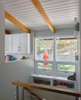 Modern home with Storage Room Type, Picture Window Type, Casement Window Type, Shelves Storage Type, Medium Hardwood Floor, Wall Lighting, and Hallway. The stairwell brightens up with new openings to the kitchen and enlarged windows to the backyard. Photo 6 of Highland Perch House