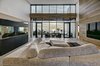 Modern home with Hardscapes, Planters Patio, Porch, Deck, Walkways, Large Patio, Porch, Deck, Decking Patio, Porch, Deck, Horizontal Fences, Wall, Grass, Shrubs, Trees, Front Yard, Boulders, Sectional, Bed, Night Stands, Wall Lighting, Ceiling Lighting, Engineered Quartz Counter, Ceramic Tile Floor, Concrete Floor, and Open Shower. living room Photo 16 of Atlantic Beach Modern