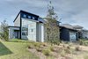 Modern home with Bed, Ceramic Tile Floor, Chair, Carpet Floor, Undermount Sink, Alcove Tub, Ceiling Lighting, Engineered Quartz Counter, Dresser, Ceramic Tile Wall, Two Piece Toilet, and Outdoor. front and side facade Photo 4 of Cedarbrook Net Zero Modern