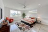 Modern home with Bed, Chair, Dresser, Carpet Floor, Engineered Quartz Counter, Undermount Sink, Alcove Tub, Ceiling Lighting, Ceramic Tile Wall, Two Piece Toilet, Trees, Shrubs, Grass, Walkways, Back Yard, Large Patio, Porch, Deck, Sofa, Concrete Floor, Table, and Stools. master bedroom Photo 11 of Cedarbrook Net Zero Modern
