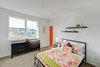Modern home with Bed, Undermount Sink, Dresser, Chair, Carpet Floor, Ceiling Lighting, Ceramic Tile Wall, Two Piece Toilet, Trees, Engineered Quartz Counter, Shrubs, Grass, Walkways, Back Yard, Large Patio, Porch, Deck, Sofa, Table, Stools, Pendant Lighting, and Wood Cabinet. kid's bedroom Photo 19 of Cedarbrook Net Zero Modern