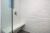 Modern home with Hardscapes, White Cabinet, Small Patio, Porch, Deck, Wood Cabinet, Horizontal Fences, Wall, Wood Tread, Ceramic Tile Backsplashe, Recessed Lighting, Accent Lighting, Refrigerator, Range, Range Hood, Dishwasher, Wood Railing, Front Yard, Concrete Patio, Porch, Deck, Metal Fences, Wall, Sectional, Ottomans, and Bookcase. porcelanosa shower tile Photo 15 of 30th Street Residence