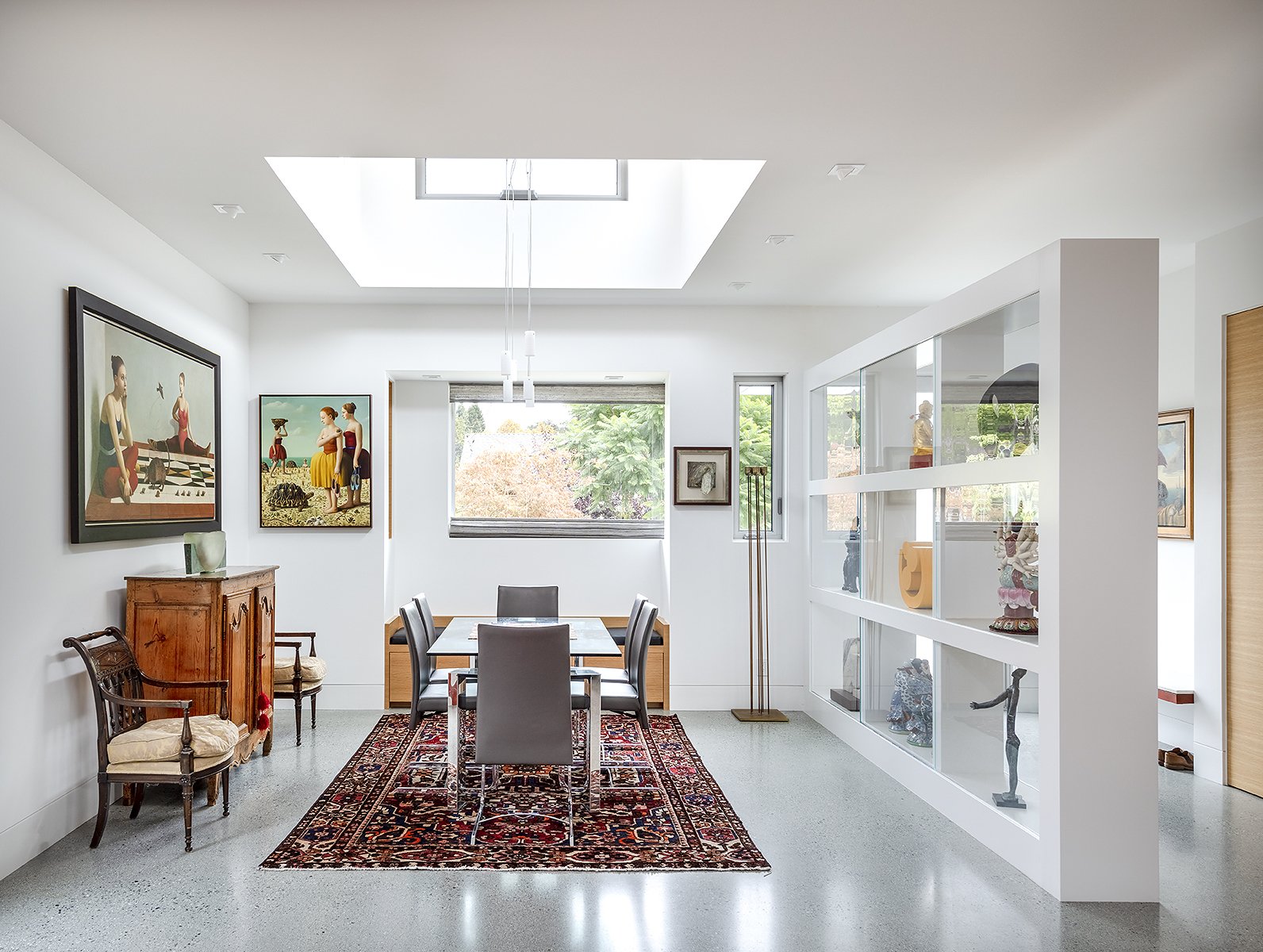 The dining room sits within an open plan, but is defined by a clerestory pop-up and a display wall.