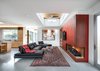 Modern home with Living Room, Two-Sided Fireplace, Gas Burning Fireplace, Accent Lighting, Concrete Floor, Sectional, Recessed Lighting, and Coffee Tables. The living room with it's clerestory pop-up, helping to define the space and bring in light. Photo 4 of Oak Street