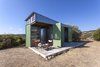 Modern home with Wood Counter, Metal Cabinet, Concrete Floor, Wood Cabinet, Chair, Coffee Tables, Table, Desert, Trees, Shrubs, Small Patio, Porch, Deck, and Doors. The Olive Tree House in Sithonia, Halkidiki, Greece Photo of The Olive Tree House
