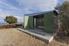 Modern home with Wood Counter, Wood Cabinet, Concrete Floor, Metal Cabinet, Coffee Tables, Table, Desert, Trees, Chair, Shrubs, Small Patio, Porch, Deck, Exterior, Metal, Folding Door Type, and Outdoor. View towards the South-East to the sea and the monasteries of Mount Athos Photo 2 of The Olive Tree House