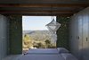 Modern home with Wood Counter, Coffee Tables, Wood Cabinet, Metal Cabinet, Concrete Floor, Chair, Table, Trees, Shrubs, Small Patio, Porch, Deck, Exterior, Metal, Folding Door Type, Metal Counter, and Shed & Studio. View to south Photo 7 of The Olive Tree House