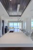 Modern home with Bed, Ceiling Lighting, Engineered Quartz Counter, Enclosed Shower, Front Yard, Undermount Sink, Freestanding Tub, Dark Hardwood Floor, Trees, Shrubs, Grass, Walkways, Kitchen, and Landscape Lighting. Kitchen island Photo 7 of NJPV