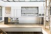 Modern home with Kitchen, Concrete Counter, Light Hardwood Floor, White Cabinet, Marble Backsplashe, Recessed Lighting, Wall Oven, Undermount Sink, and Microwave. An expansive skylight extends the full width and length of the kitchen, flooding natural light into the core of the open and connected living spaces.
Photo 6 of Spruce
