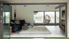 Modern home with Living Room, Chair, Sectional, End Tables, Coffee Tables, Console Tables, and Porcelain Tile Floor. NanaWall bifold glass doors open to the living room and den, allowing views from the back lawn to the front courtyard. Photo 16 of Diablo Ranch