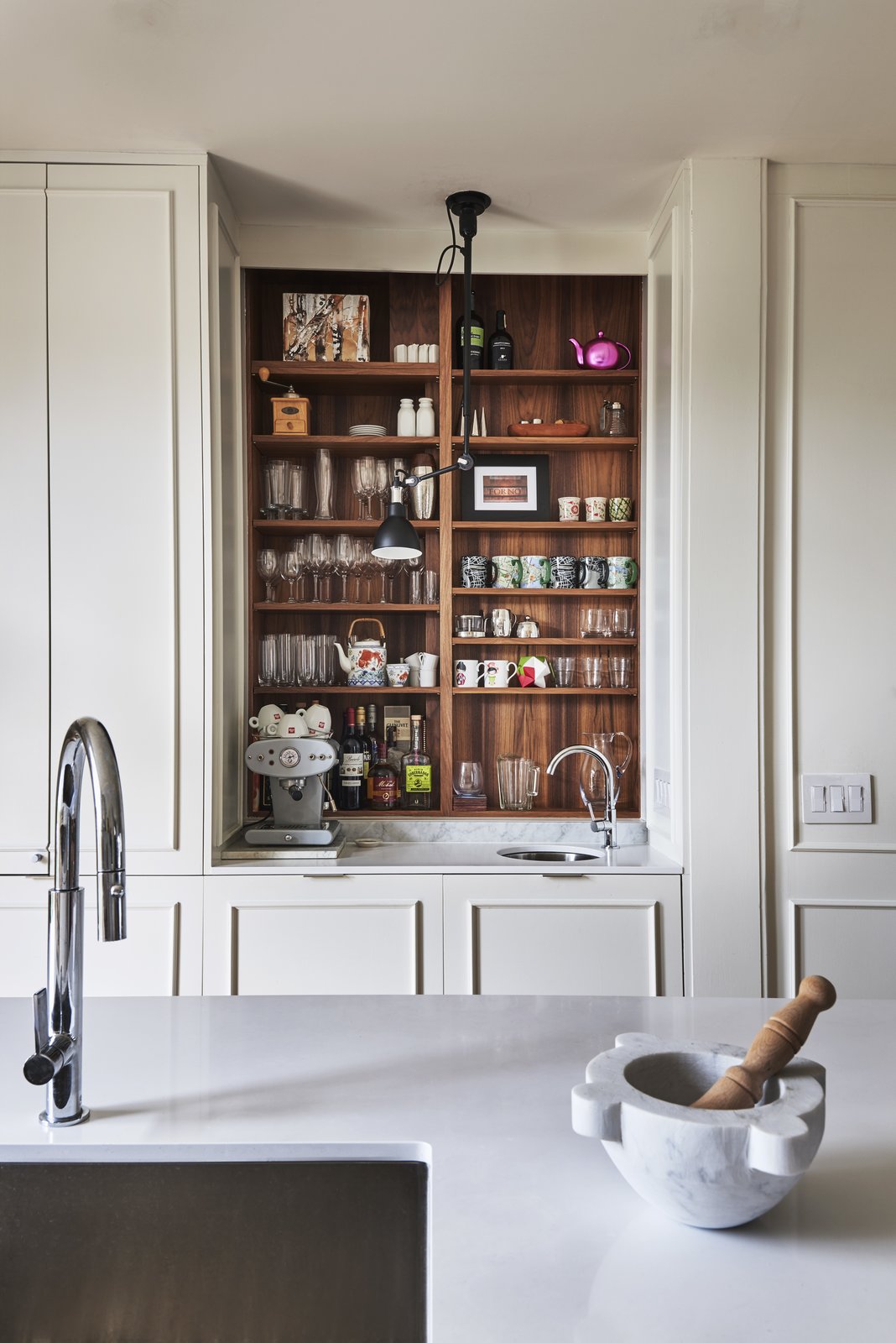 The bar/coffee niche is extremely functional and allows for the cook to work undisturbed.  The walnut shelving ties back to the walnut island