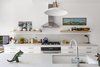 Modern home with Kitchen, Wall Oven, Range, Open Cabinet, White Cabinet, Undermount Sink, Pendant Lighting, Range Hood, and Table Lighting. Solid wood shelves can be a great way to add contrast and texture a kitchen, especially an all-white one. If you're looking to add more fun pops of personality, opt for decorative brackets. Photo 6 of Bed Stuy Family Adobe