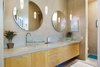 Modern home with Bath Room, Vessel Sink, Concrete Floor, Pendant Lighting, Stone Counter, and Stone Tile Wall. The neutral master bath includes double glass vessel sinks, custom maple cabinetry and oversized limestone tiles. Photo 9 of Santa Fe Contemporary