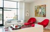 Modern home with Living Room, Sofa, Coffee Tables, Chair, End Tables, Ceiling Lighting, Light Hardwood Floor, and Gas Burning Fireplace. Living room with view of rear deck and garage Photo 6 of Modern Building Approved in Jackson Ward-Historic district