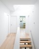 Modern home with Wood Tread, Metal Railing, Hallway, and Light Hardwood Floor. A projecting skylight offers an additional source of daylight from above, allowing light to pass down to all three floors below. Photo 7 of Pink House