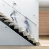 Modern home with Staircase, Wood Tread, and Metal Railing. The stair, an architectural piece in itself, composed of glass balustrades and open risers, allows light to fall further into the interior. Photo 8 of Pink House