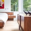 Modern home with Bedroom, Bed, Table Lighting, Dresser, Light Hardwood Floor, and Night Stands. Custom platform bed by Christian Woo lies perfectly beneath the bedroom windows. Photo 10 of Pink House