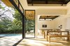 Modern home with Dining Room, Floor Lighting, Chair, Wall Lighting, and Bench. Large, operable glass doors and clerestory windows provide a fluid transition between the interior retreat and the exterior landscape. Photo 5 of Nalu Nosara