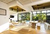 Modern home with Dining Room, Table, Chair, Bench, Stools, Floor Lighting, and Light Hardwood Floor. The wood tones in the ceiling are reflected in wood flooring and wood furniture introduced throughout the floor plan, adding warmth and texture. Photo 6 of Nalu Nosara