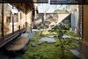 Modern home with Outdoor, Garden, Trees, Gardens, Grass, Boulders, Wood Fences, Wall, Vertical Fences, Wall, and Concrete Fences, Wall. A lounge space looks onto a calming moss garden and provides the perfect zen setting to relax with a cup of tea. Photo 3 of Nichinichi Townhouse