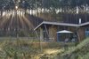 Modern home with Exterior, Wood Siding Material, Cabin Building Type, and Glass Siding Material. Maritime pines from the Landes Forest compose the exterior wood cladding of each hut and purposefully form the incredible views outward to the lake. The wood frame segues into an angular, butterfly roof that collects and directs rainwater back into the lake. Furthermore, it provides shading where full-height windows open into the living space. By orienting each hut in the same direction, the architects create a sense of isolation within the wood enclosure. Photo 4 of Les Echasses