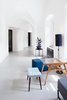 Modern home with Hallway and Concrete Floor. Mid-century modern furniture pieces with blue pastel upholstery and warm wood tones accent the white, bright corridors. Photo 16 of Long Story Short Hostel