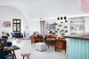 Modern home with Living Room, Sofa, Ottomans, Bookcase, Coffee Tables, Chair, Wall Lighting, and Concrete Floor. The reception space is the heart of the hostel, providing lounge areas adjacent to the cafe. Photo 14 of Long Story Short Hostel