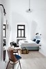 Modern home with Bedroom, Chair, Bed, Light Hardwood Floor, Pendant Lighting, and Wall Lighting. Private rooms provide lush, comfortable accommodations with arched ceilings and day lit filled interiors. Photo 3 of Long Story Short Hostel
