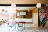 Modern home with Dining Room, Chair, Table, Bar, Pendant Lighting, Bench, Terrazzo Floor, and Ceiling Lighting. The Lobby Reception space is adorned with mid-century modern pendant lighting, tropical wall graphics, and color furnishings. Photo 4 of The Drifter Hotel