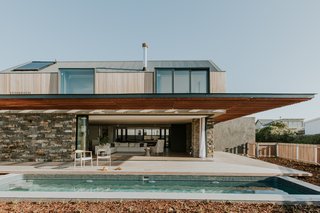 The large, sliding doors pocket into the deep stone walls, completely opening up the living space to the outdoors.