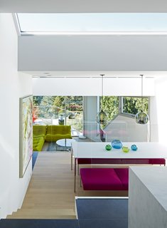 The kitchen and dining space are centrally located at the heart of the home. An island becomes the perfect location for work, play, homework, and eating, with views of the living spaces below.