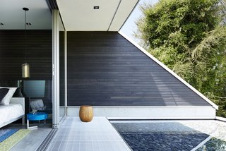 A quiet reflecting pond lies directly outside the master suite. The exterior siding passes onto the interior, creating a seamless connection between the two spaces.