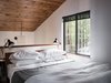 Modern home with Bedroom, Bed, and Table Lighting. At the head of the bed in the main bedroom, a half-height wall overlooks the dining space below. Photo 6 of MiniMod Cabin