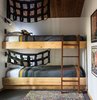 Modern home with Bedroom, Bunks, Wall Lighting, and Rug Floor. In the second bedroom, built-in bunk beds add a flair of fun, decorated with black netting. Photo 7 of MiniMod Cabin