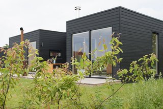 Clad in black-washed decking, the simple structure makes a quiet statement in the natural setting. While its thoughtful layout provides plenty of space for family gatherings, the cabin is also an idlliic setting for a private hideaway. 