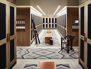 There is also a boot room and changing area for skiers, which features rustic wooden lockers, dark accents, and decorative rugs to continue to draw in the mountain style.