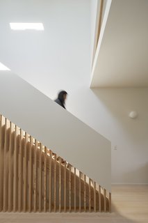 By incorporating wood slats into the stair wall, light from above is able to pass farther into the space between levels.

