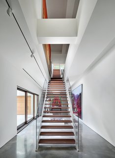 The long, wood stairs appear as a screen, quietly revealing artwork between levels and spaces. 