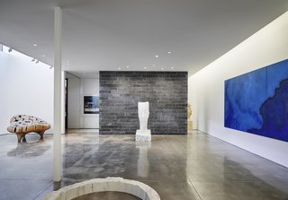 The below-grade gallery space much resembles a modern art gallery. White walls and concrete floors provide the ideal backdrop for the curated collection of art, accented by indirect lighting.

