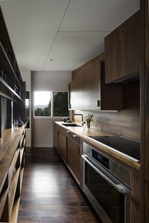 Dark brown wood contrasts with the bright, white wall and ceiling finishes. In the kitchen, modern appliances meet today's needs.